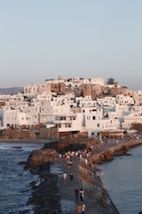 a group of people walking along a beach next to the ocean