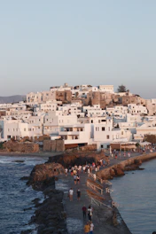 a group of people walking along a beach next to the ocean