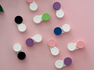 A vibrant display of colorful contact lens boxes arranged neatly on a wooden shelf.