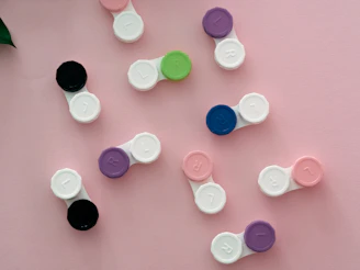 Close-up of colorful contact lenses arranged in a fan shape on a soft fabric background