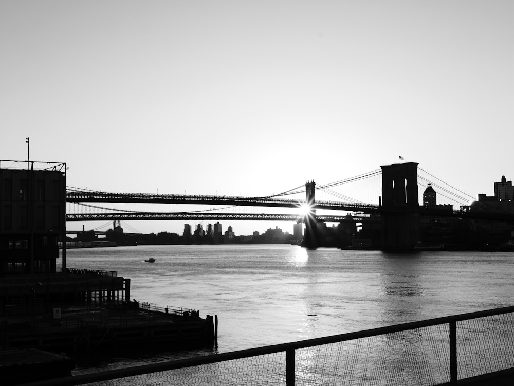 Una foto in bianco e nero di un ponte su un fiume
