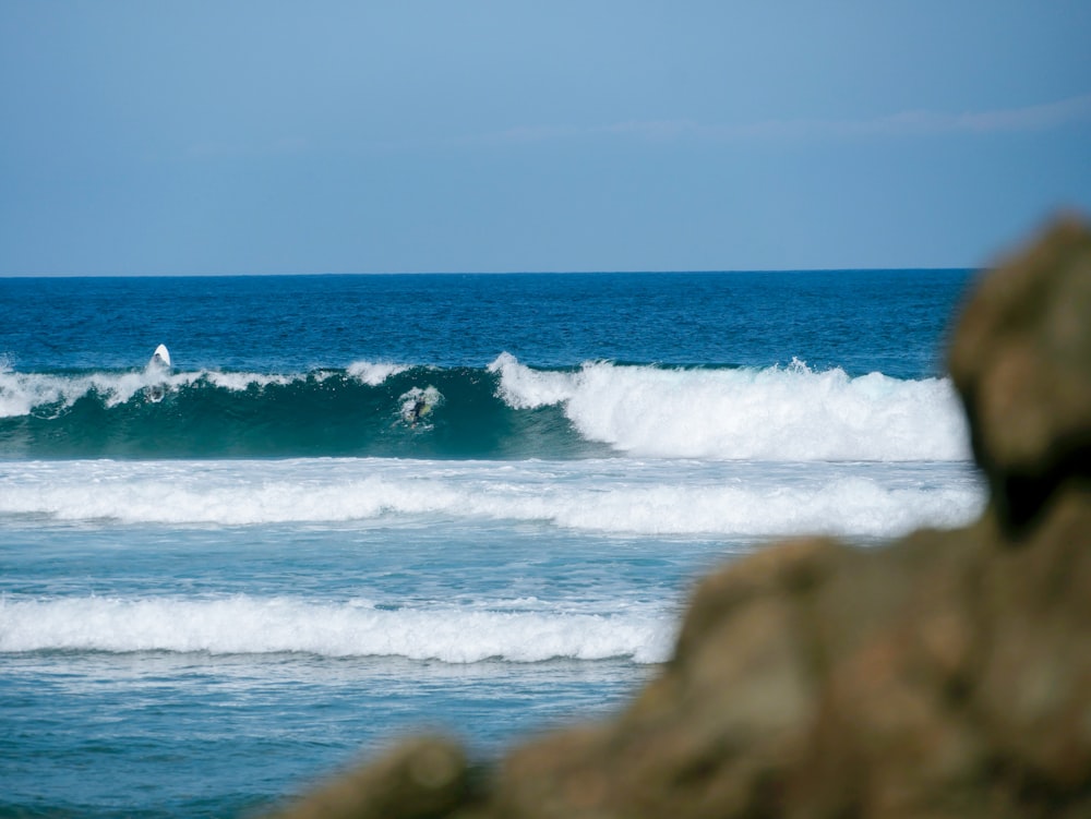 a man riding a wave on top of a surfboard