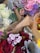 A collection of floral arrangements featuring a variety of flowers. Prominent colors include pink, purple, red, and white roses and carnations, along with green leaves and silver-grey dusty miller foliage. The bouquets are wrapped in brown paper.