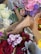 A collection of floral arrangements featuring a variety of flowers. Prominent colors include pink, purple, red, and white roses and carnations, along with green leaves and silver-grey dusty miller foliage. The bouquets are wrapped in brown paper.
