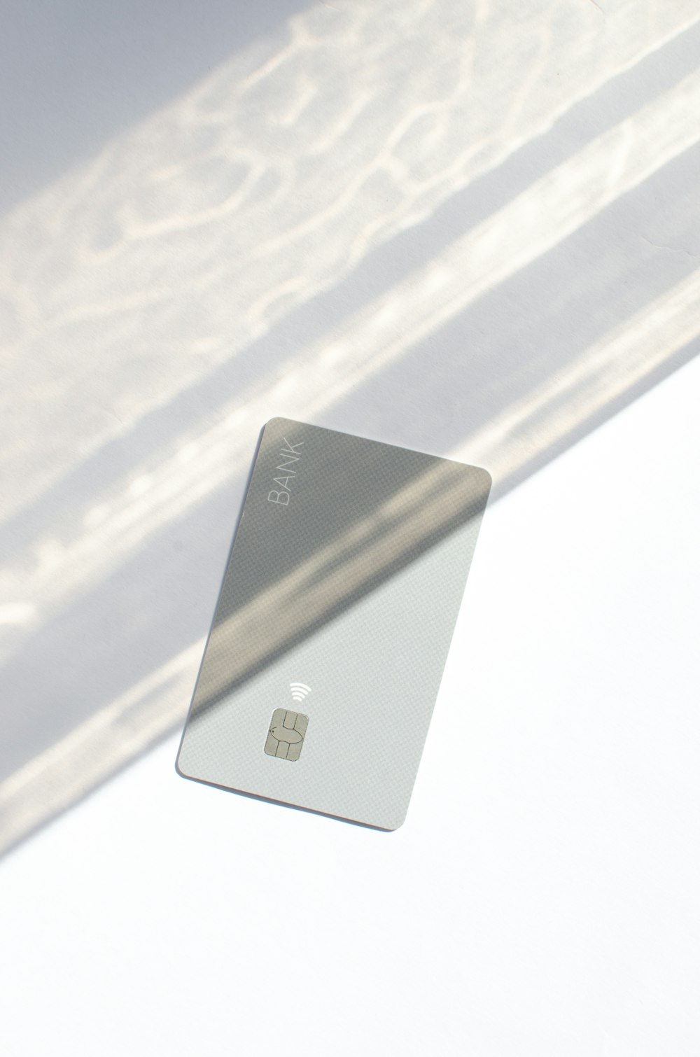 um cartão de crédito prateado sentado em cima de uma mesa