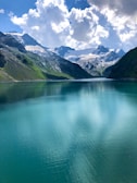 A serene mountain lake reflecting snow-capped peaks under a clear blue sky.