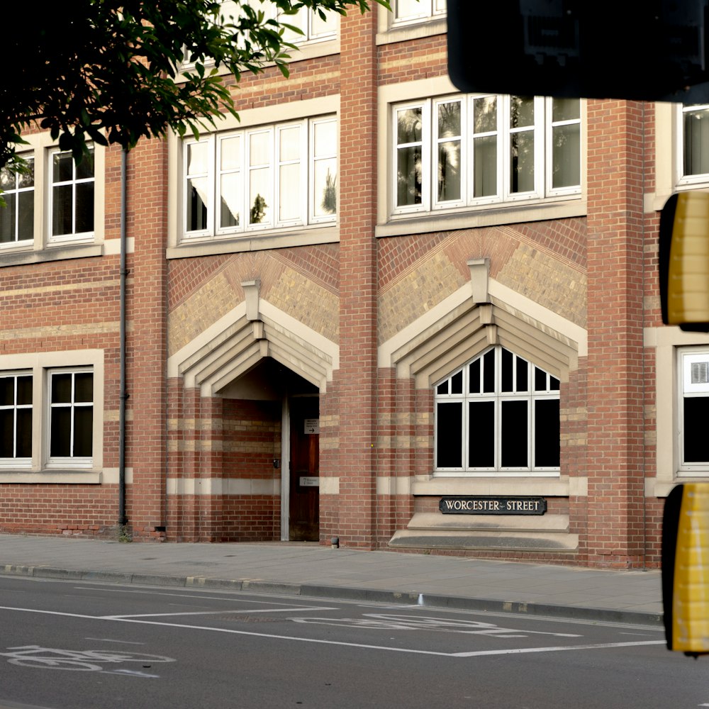 a red brick building with white windows on a street corner