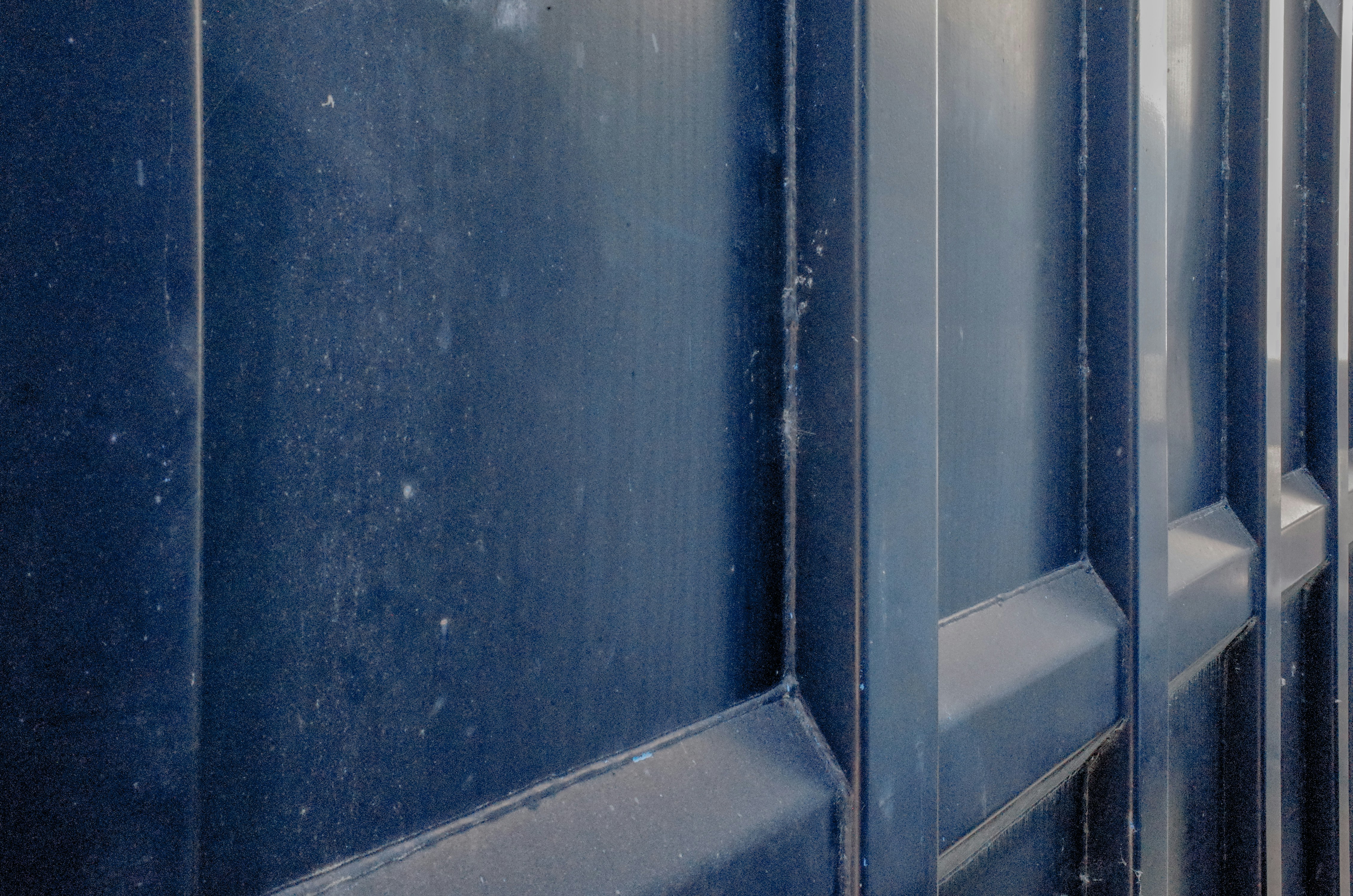 a close up of a metal door with blue paint