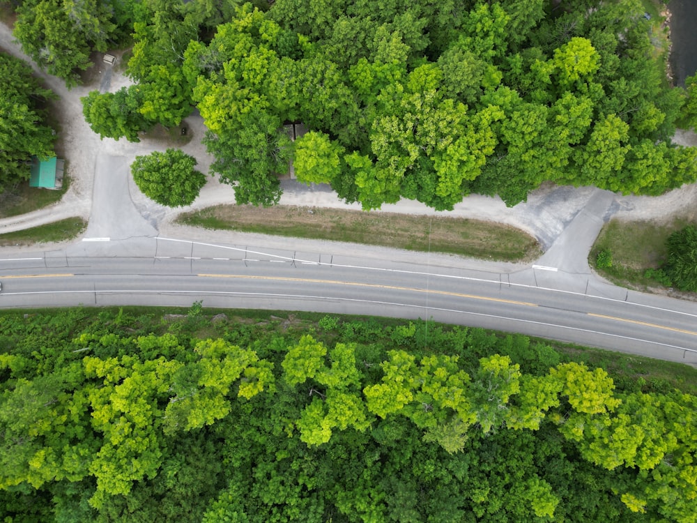 an aerial view of a road surrounded by trees