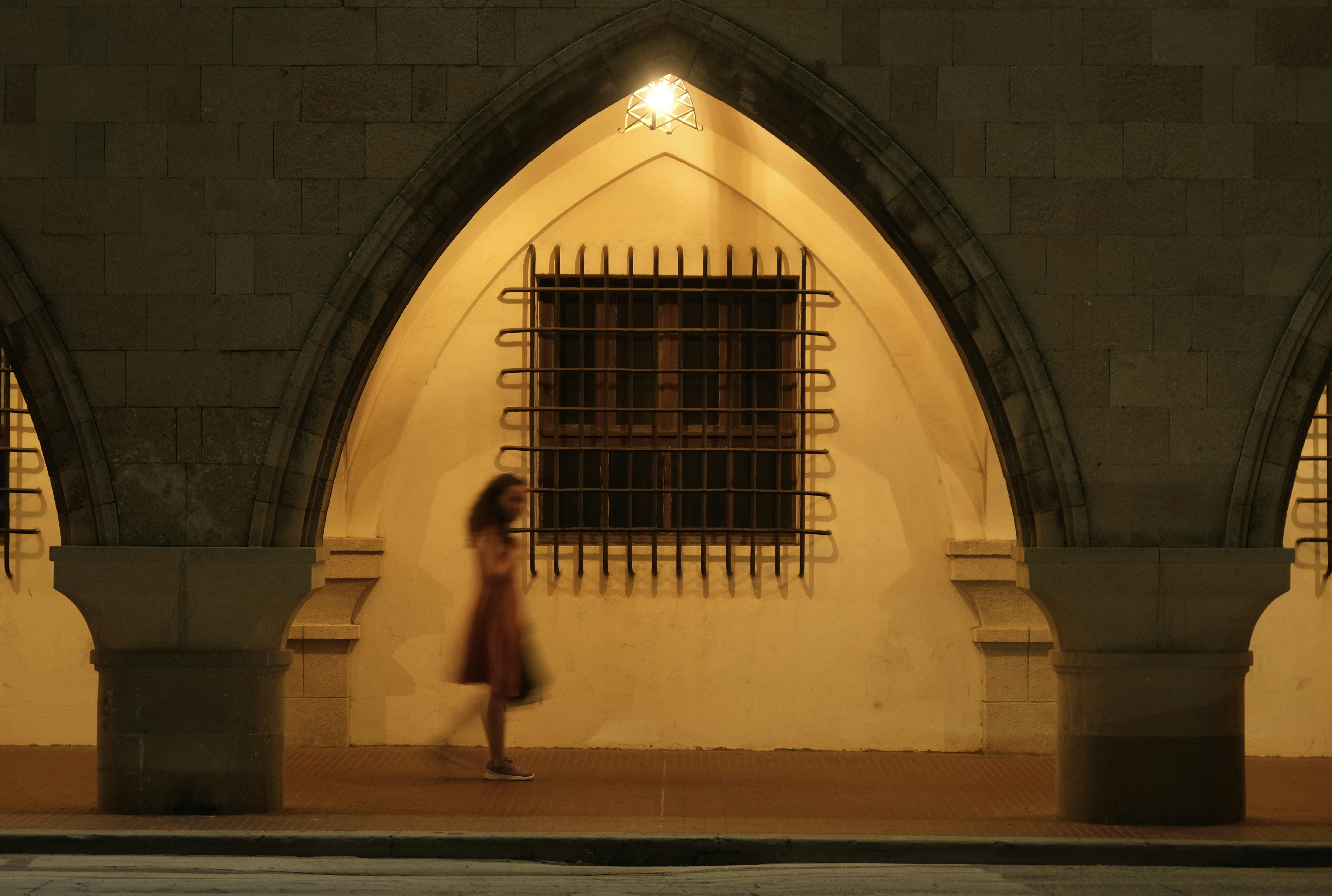 a woman walking down a street at night
