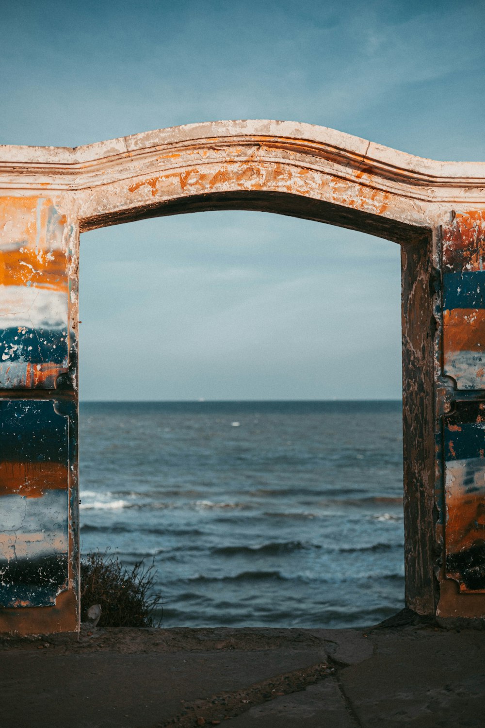 an old wooden arch over looking a body of water