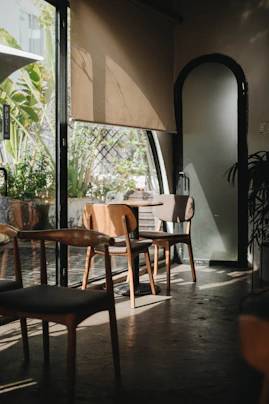 A serene coaching session in a cozy, sunlit room with plants and soft cushions.
