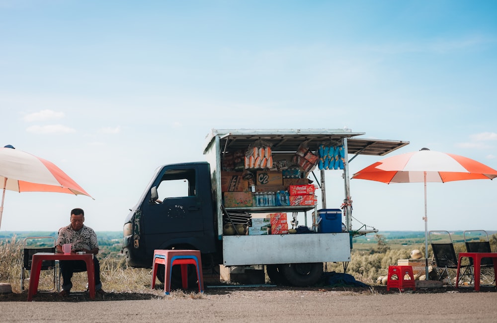 a man sitting at a table in front of a truck