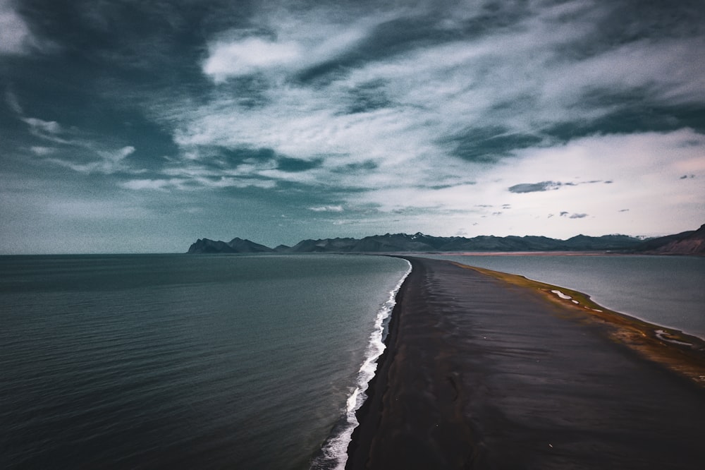 a large body of water sitting under a cloudy sky