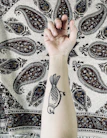 Close-up of a client’s arm showcasing a freshly finished tribal tattoo with bold lines