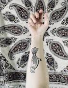 Close-up of a client’s arm showcasing a freshly finished tribal tattoo with bold lines