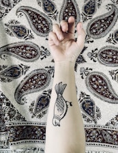 Close-up of a detailed black and grey tattoo on a person's forearm