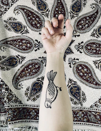 Close-up of a tribal freehand tattoo being inked on a forearm with fine detail and shading