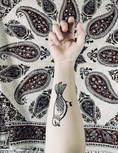 Close-up of a detailed black and gray tattoo on forearm showing fine line work.