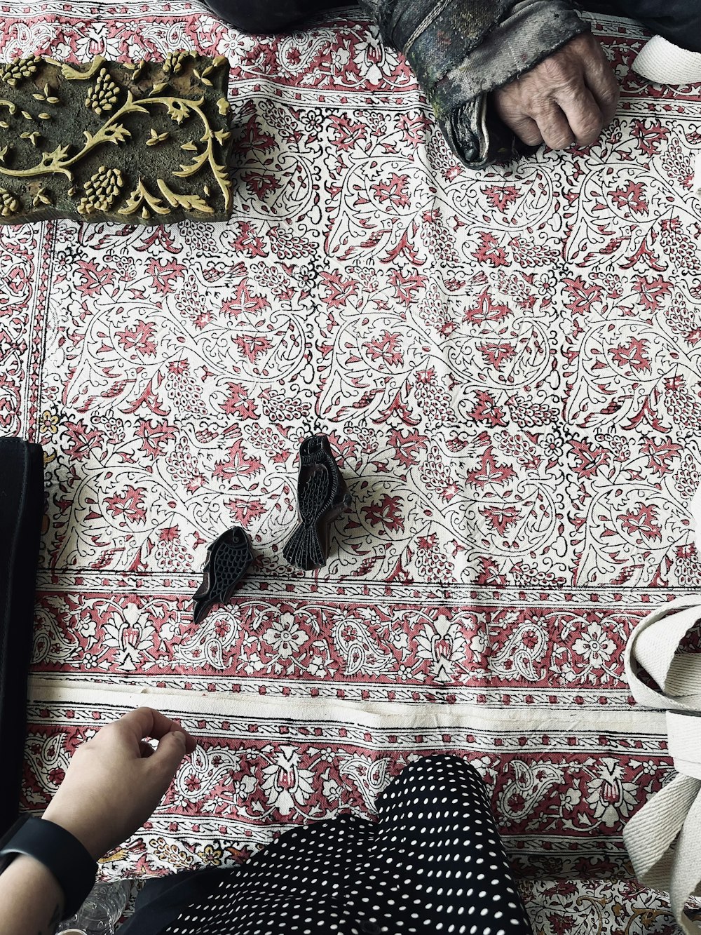a person sitting on a rug with a pair of shoes on the floor