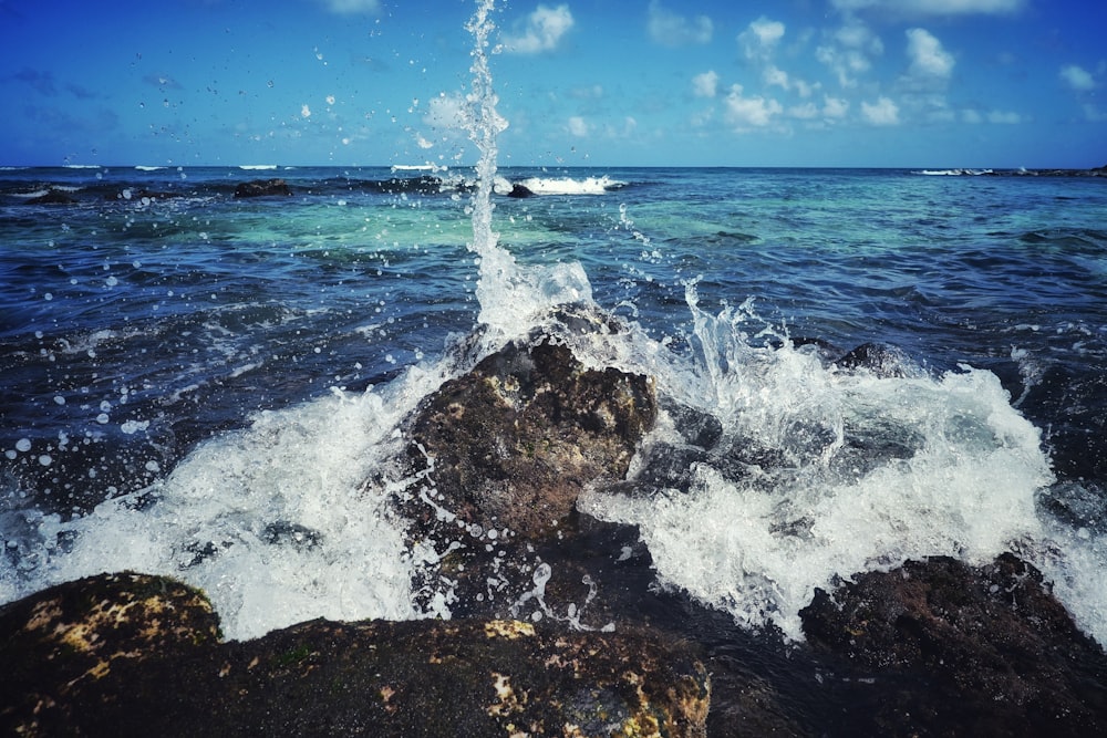 a large body of water with rocks in the foreground