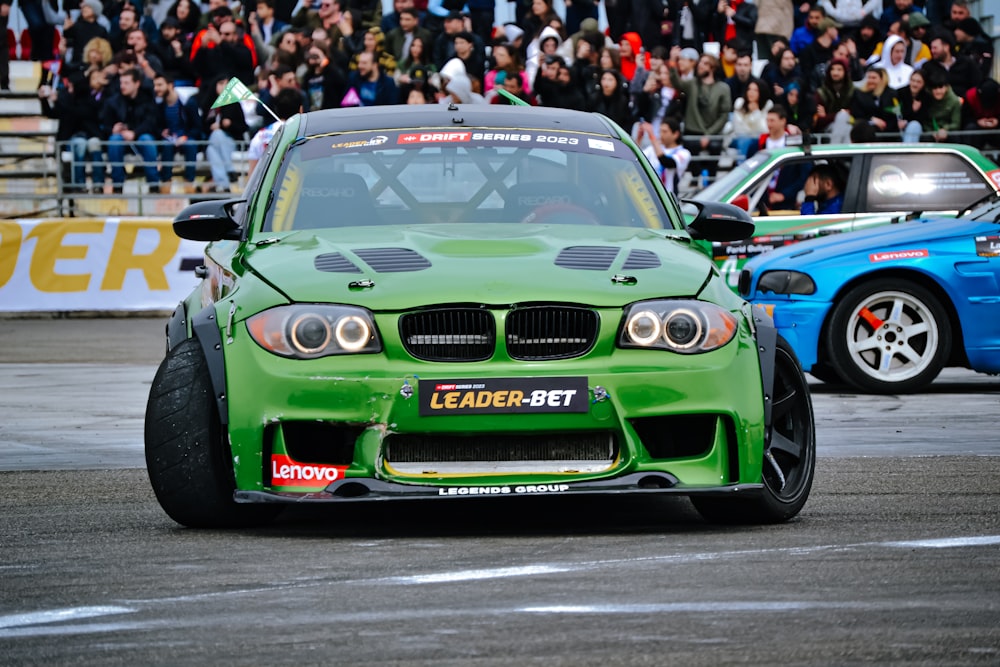 a green car driving down a race track