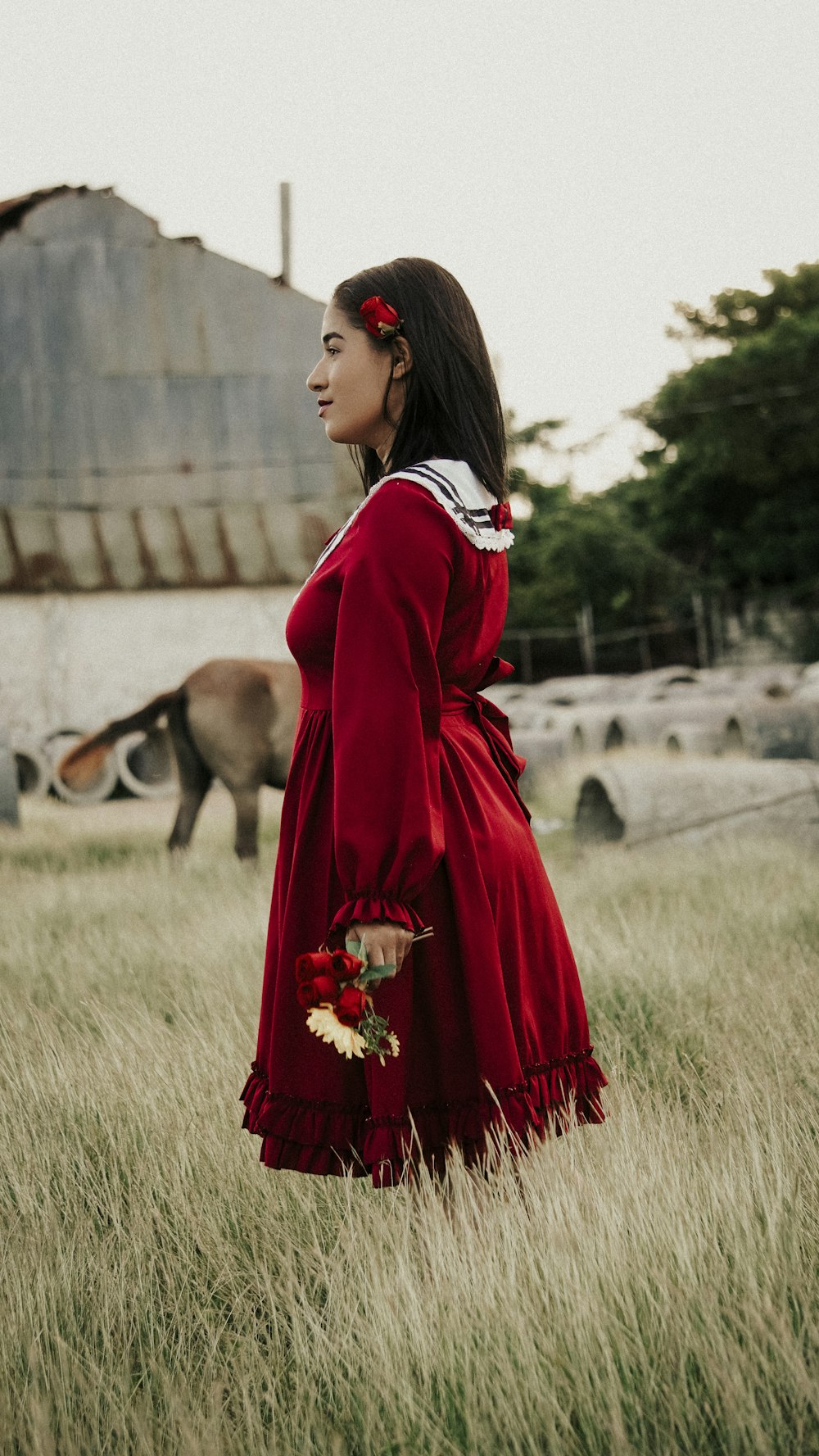a woman in a red dress standing in a field