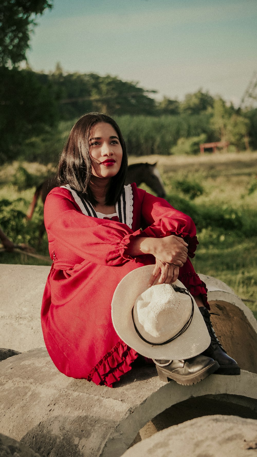 a woman in a red dress sitting on a barrel