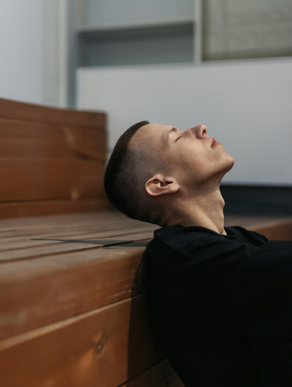 a man with his head resting on a bench