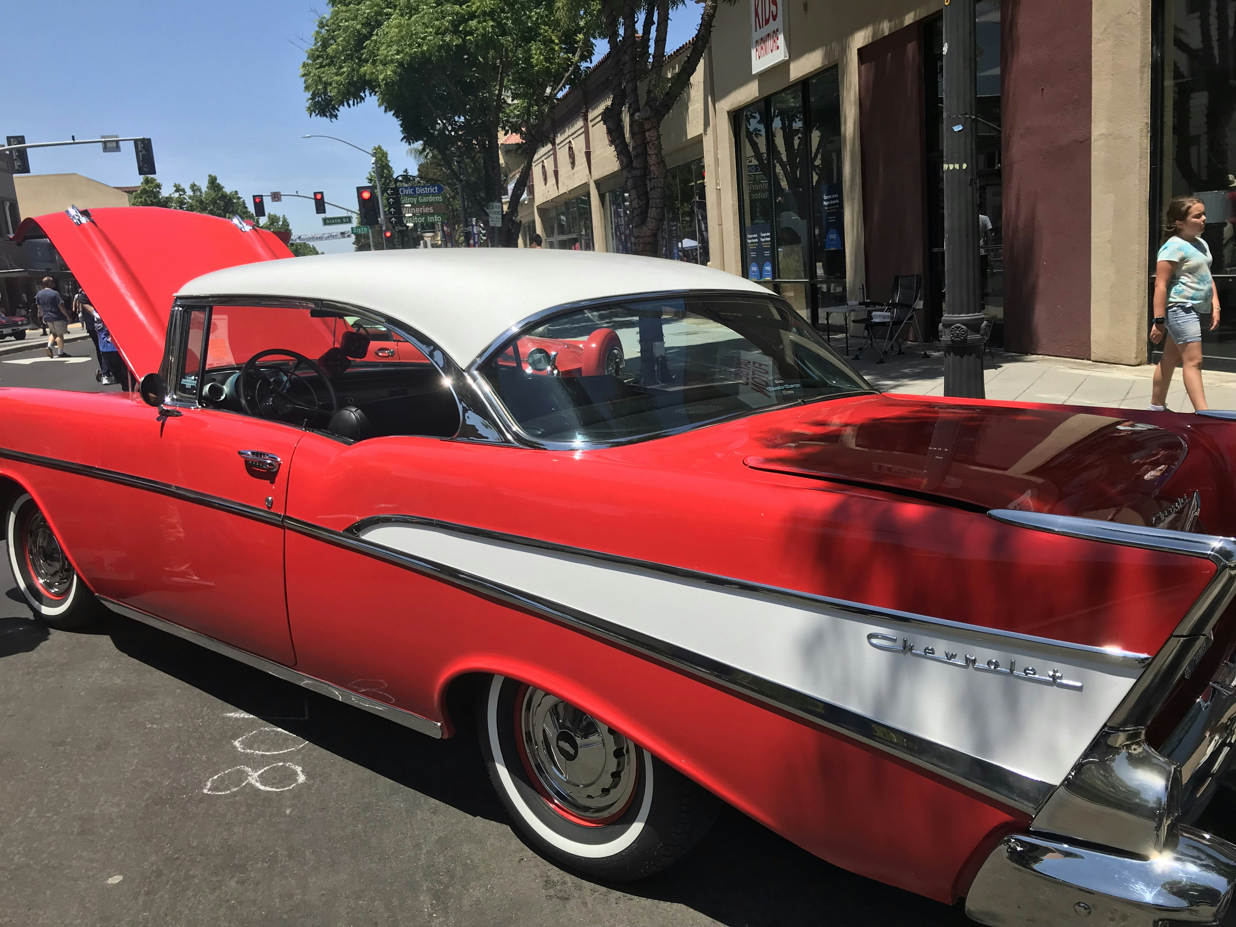 a red and white car parked on the side of the road