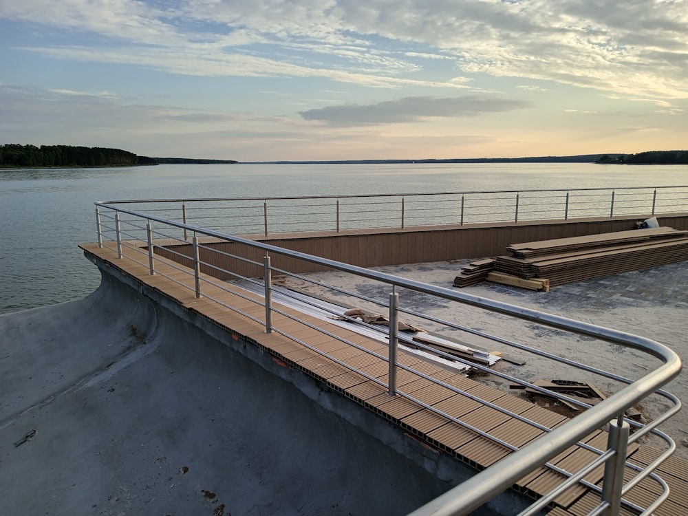 a boat dock with benches and railings next to the water