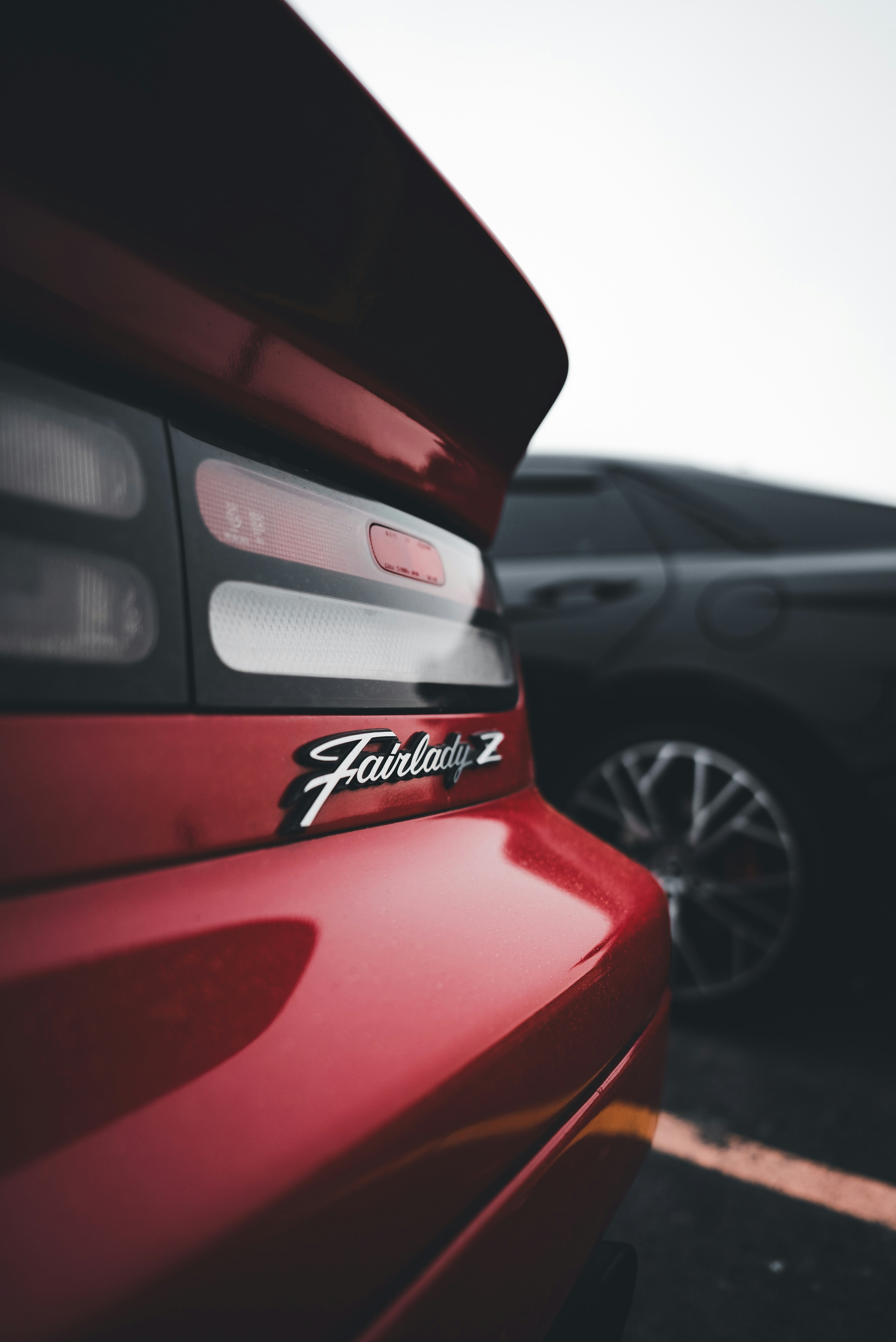 ein rotes Auto, das auf einem Parkplatz neben einem anderen Auto geparkt ist