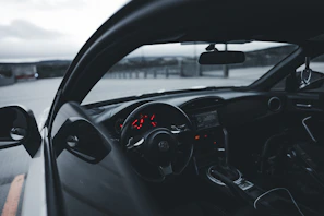 Close-up of a sleek red sports car dashboard with illuminated controls