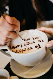A steaming cup of coffee with a detailed face printed on the foam.