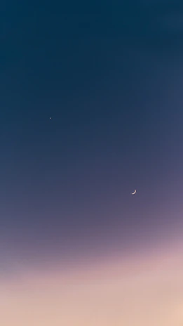 Gentle night sky with twinkling stars and a crescent moon casting a peaceful glow over an open devotional journal.