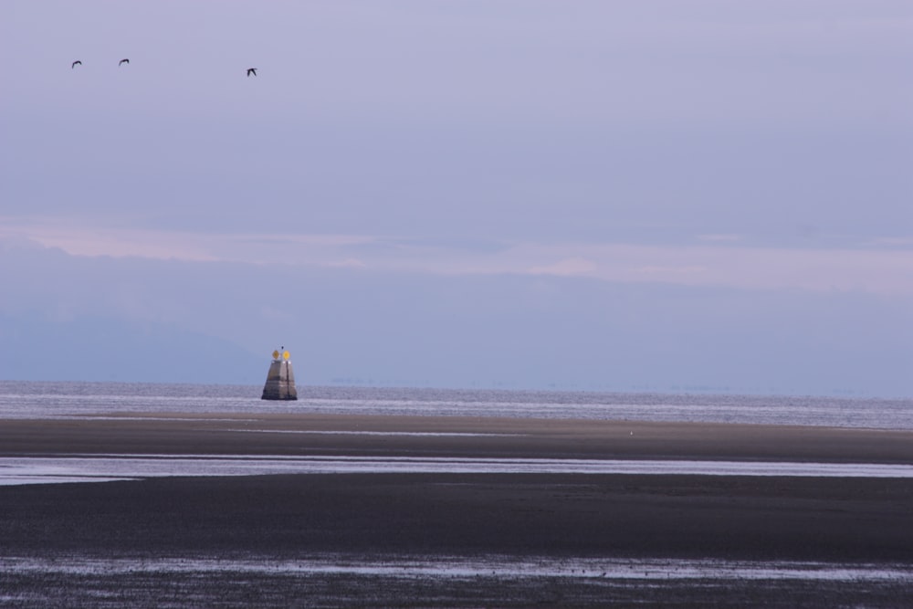 a lighthouse in the middle of a large body of water