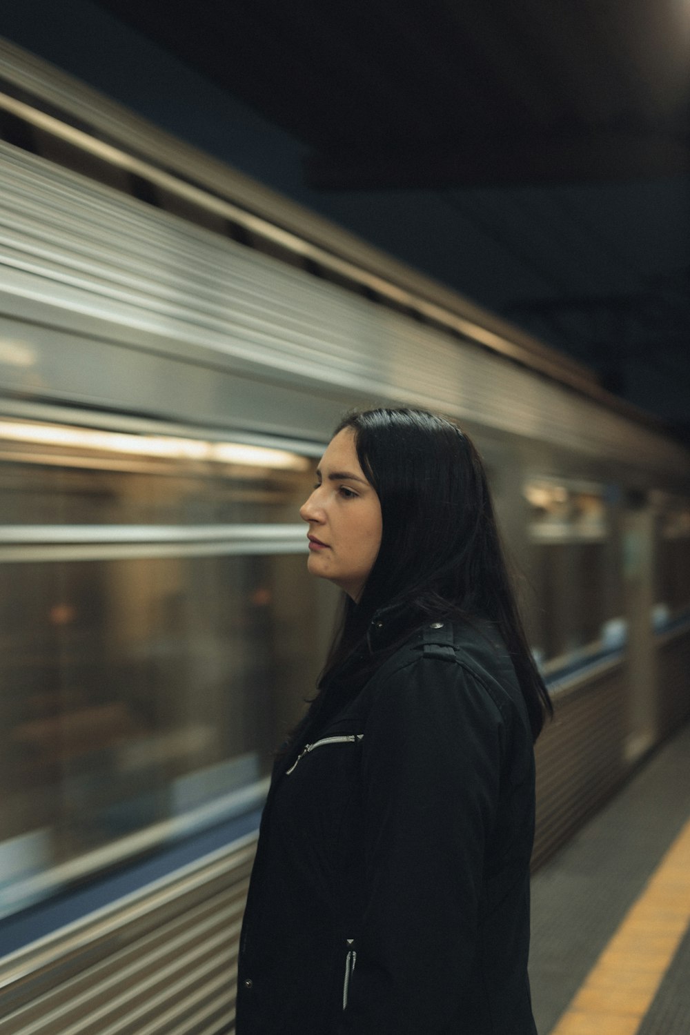 a woman standing in front of a subway train