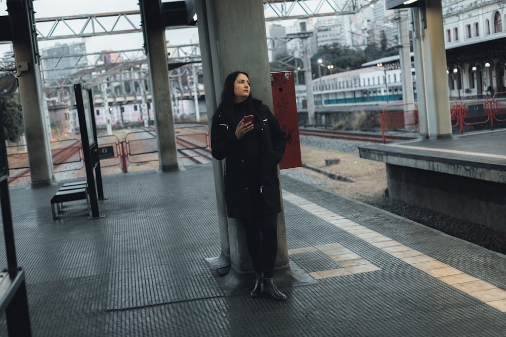 a woman standing on a train platform next to a train