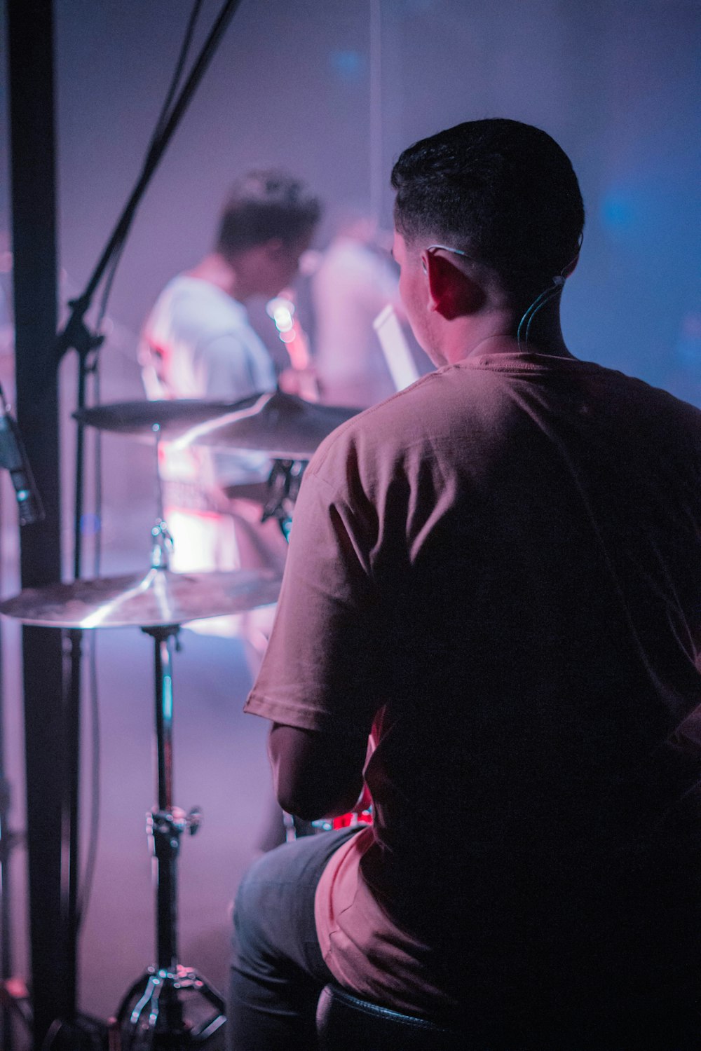 a man sitting in front of a drum set