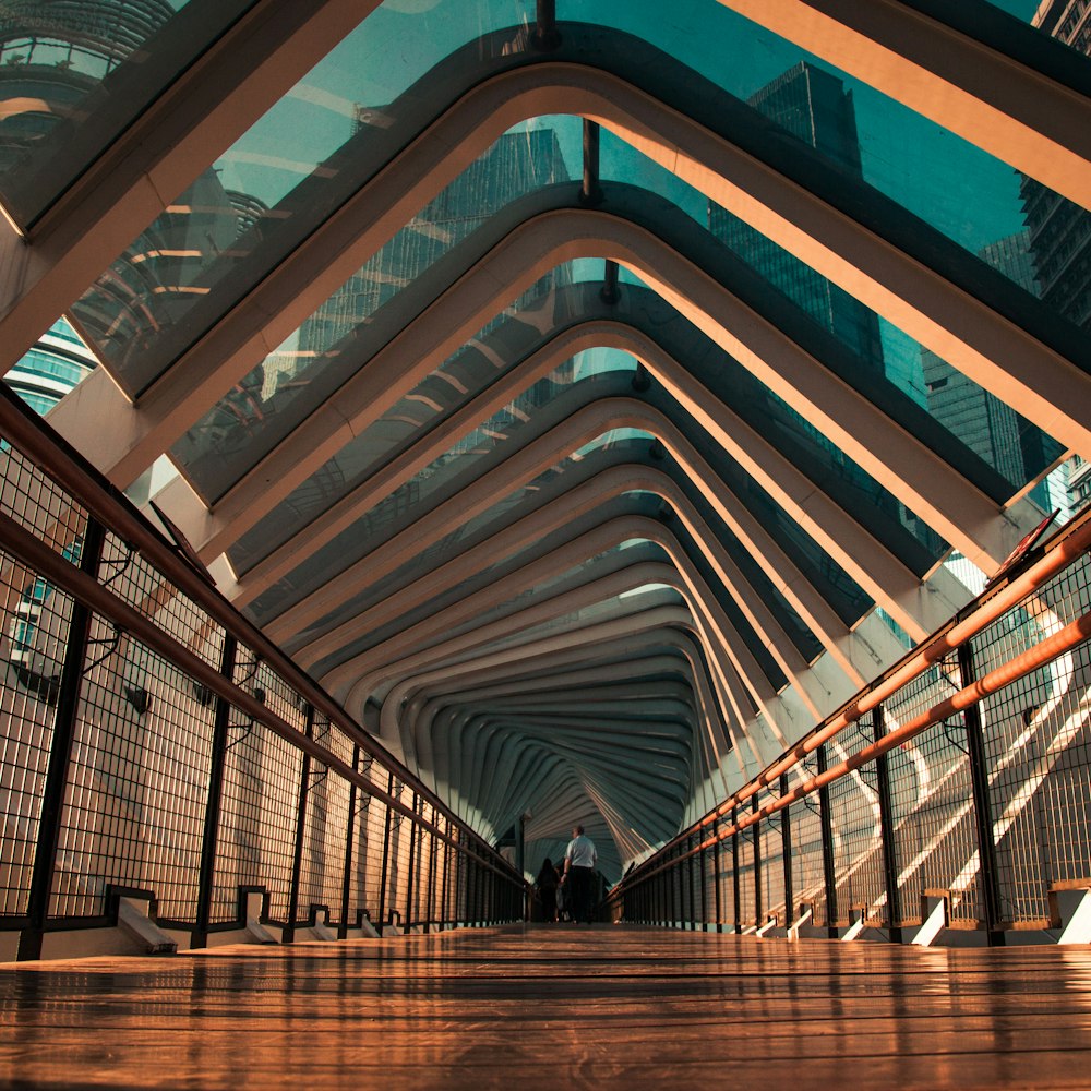 a long hallway with a metal railing and a skylight