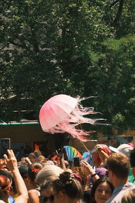 A lively crowd gathered around a colorful road show booth on a sunny day.