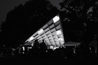 A large pyramidal tent hosting a corporate event with elegant lighting inside.