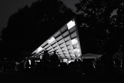 A sturdy temporary roof covering a lively event space filled with guests.
