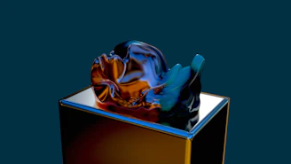 Close-up of a vibrant mixed-media sculpture displayed on a sleek pedestal.