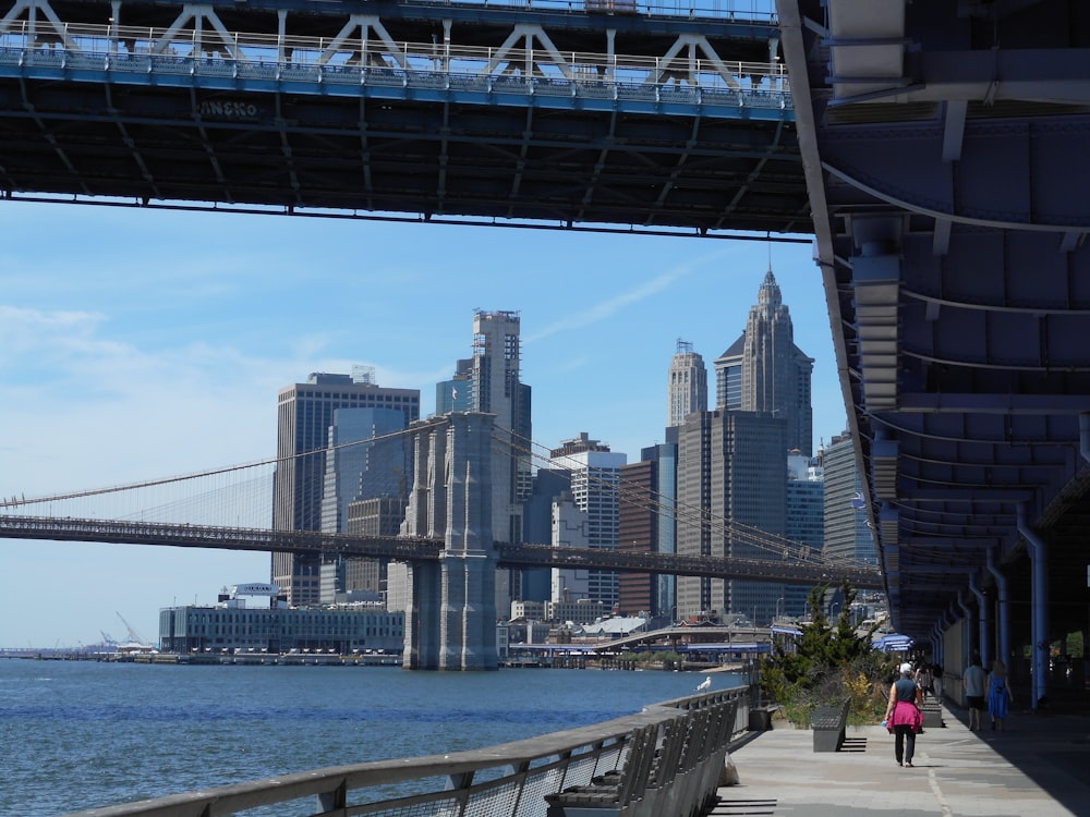 a bridge over a body of water with a city in the background