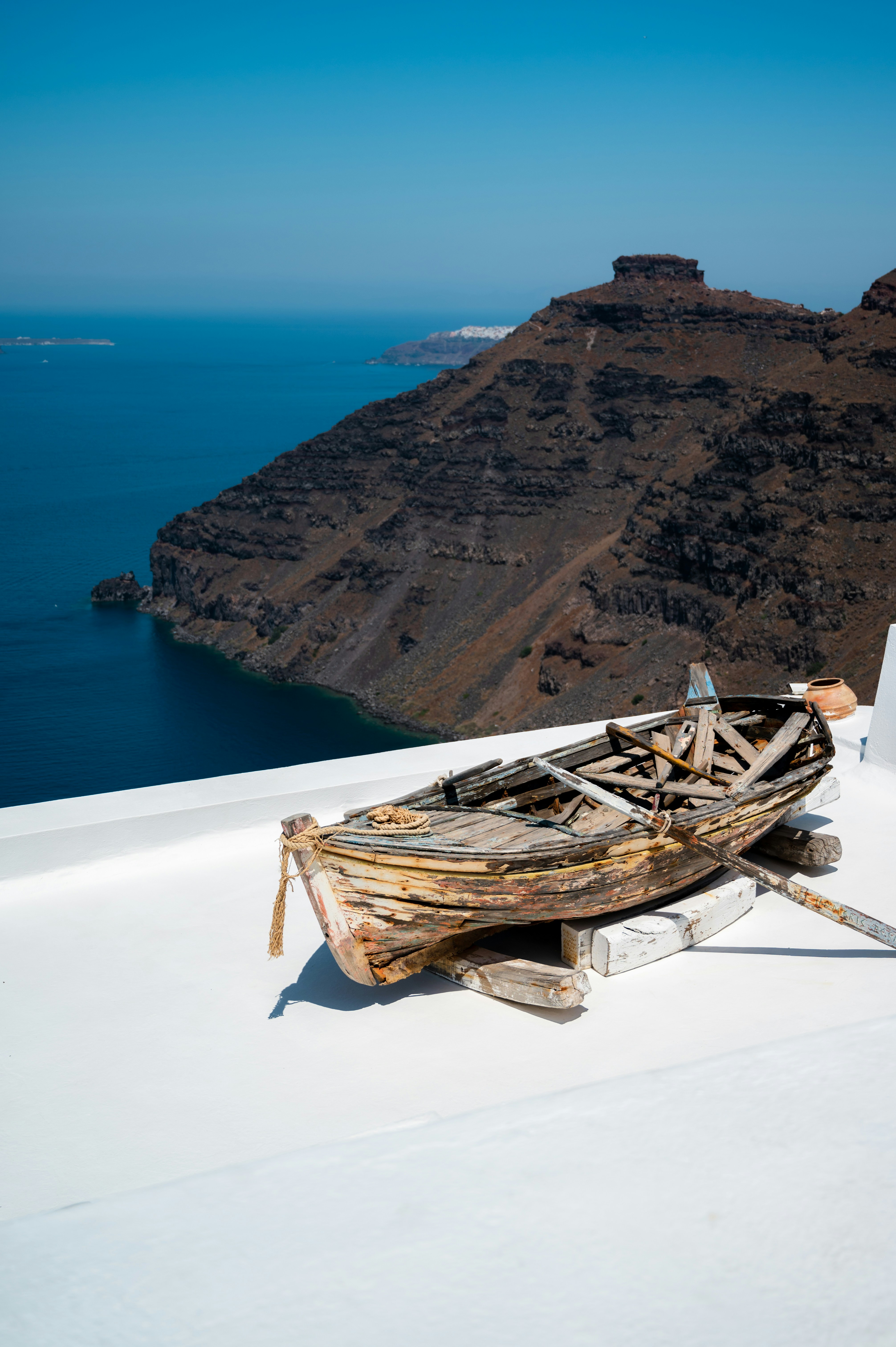 a boat sitting on top of a roof next to a body of water