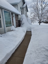A snow-covered property with clear walkways after a snow removal service.