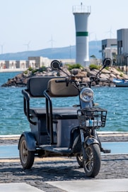 a scooter is parked on the side of the road near the water