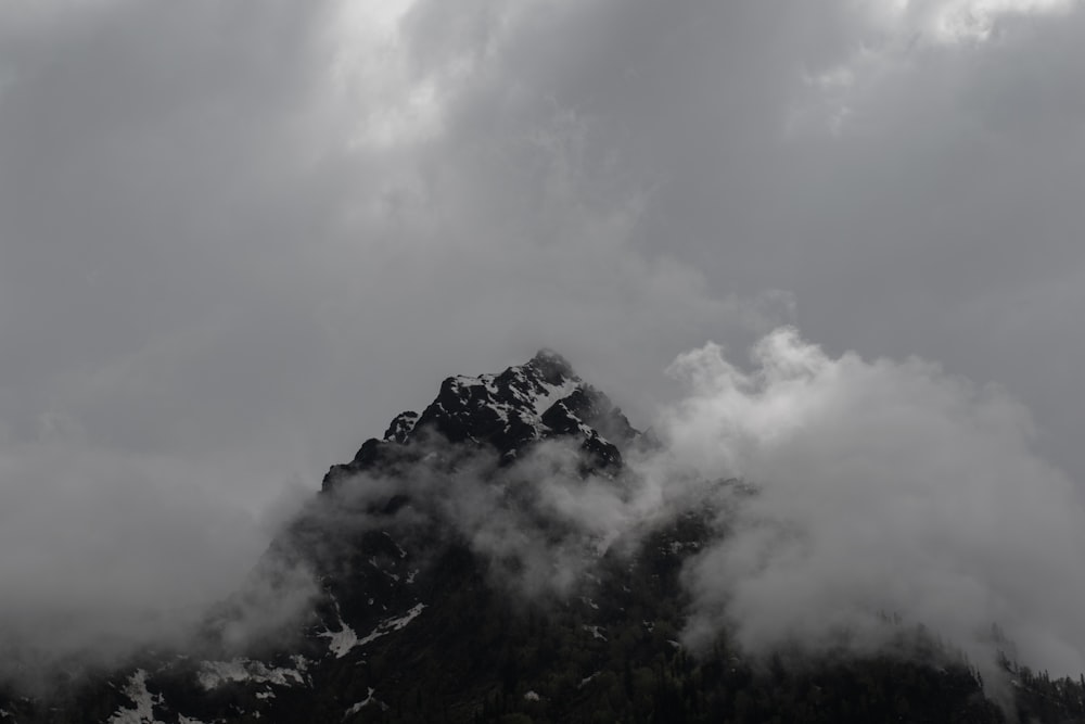 a mountain covered in clouds on a cloudy day