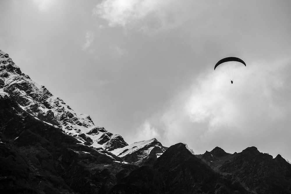 a paraglider is flying over a mountain range